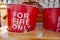 Old and worn red fire buckets in wooden stand