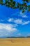 Old wreck fishing boat buried in the sand with blue sky on cloud