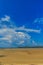 Old wreck fishing boat buried in the sand with blue sky on cloud