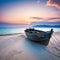 An old wrecked fishing boat rides on a deserted An abandoned wooden