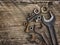 Old wrenches on the nuts and bolts on a wooden grungy background