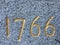 Old year 1766, golden numerals on grey granite background. MDCCLXVI.