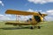 An old yellow biplane airplane from the early 20th century.