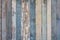 Old yellow blue white wooden wall fence of wooden boards with peeling paint. vertical lines. rough surface texture