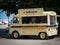 An old yellow car adapted to sell ice cream