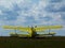 old yellow double wing bi-plane on open green grassy airfield