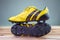 Old yellow football shoes placed on a wooden board, gray background Soft light