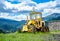 Old yellow grader on mountainous road construction