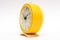 Old yellow mechanical alarm clock on white background