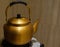 Old yellow metal teapot on the stove