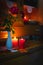 Old yellow painted cupboard with candles, a vase with red roses, autumn leaves and crocheted doilies