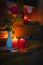 Old yellow painted cupboard with candles, a vase with red roses, autumn leaves and crocheted doilies