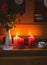 Old yellow painted cupboard with candles, a vintage cup, a vase with red roses, autumn leaves and crocheted doilies