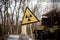 Old yellow radiation sign against a blurred background of equipment that participated in the liquidation of the accident