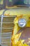 Old yellow rusty Chevrolet pickup truck grille and headlight