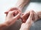 Old and young holding hands on light background, closeup. Care is at home of elderly