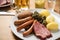 Oldenburger green cabbage with sausage mix, Kassler pork neck, boiled potatoes, mustard, beer and grain liquor is an traditional