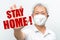 Older Asian man wearing N95 mask holding out his hand with palm out stretch to stop COVID-19 virus with red text STAY HOME