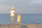 Older brother holds the little sister by the hand and looks at the sea. Siblings. Vacation at sea