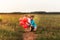 Older brother hugs sister in the summer in nature