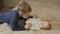 The older brother plays with his little sister, holding her hands.