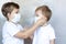 The older brother puts on a medical mask for his younger brother. Coronavirus, disease, infection, quarantine, medical mask, COVID