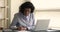 Older businesslady sit at desk texting use laptop, takes notes