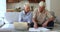 Older couple discuss family budget, reviewing household bills
