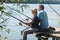 Older couple sitting on pontoon and fishing