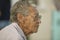 A older Cuban man with wrinkles and glasses looks outward in El Rincon, Cuba