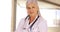 An older doctor poses for a portrait in her office