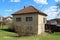 Older family house in suburb with cracked dilapidated windows and balcony fence waiting for renovation and new facade