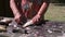 Older female fisherman cleans the scales of a lively big fish