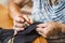 Older grandmother enjoys sewing by hand relaxed in her home