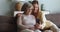 Older grandmother and grownup granddaughter spend time together using smartphone