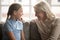 Older grandmother and teen granddaughter chatting gossiping