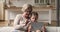 Older granny and little granddaughter resting on couch with tablet