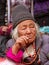 Older gray-haired ladakhi women in traditional clothes and jewelry among the crowd of observers watching Yuru Kabgyat festival