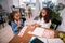 Older loving sister helping her little sister studying letters sitting in cafe