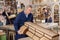 Older male furniture maker sanding vintage commode in workshop