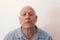 Older man head back with bad attitude, bald, alopecia, chemotherapy, cancer, on white