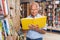 Older man reader browsing inside of books in bookshop