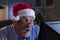 Older man in Santa hat looking shocked, horizontal