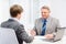 Older man and young man having meeting in office