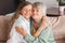 Older mature mother and grown millennial daughter laughing embracing, caring smiling young woman embracing happy senior middle