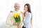 Older mother and adult daughter with bouquet of flowers