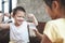 Older sister giving a glass of milk to her young brother and he is smiling and making strong body gesture