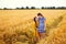 The older sister hugs and comforts the younger one. Girls in dresses in the summer in a wheat field. Image with selective focus