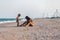 Older sister playing with younger brother aground near the shore on summer vacation