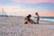 Older sister playing with younger brother aground near the shore on summer vacation